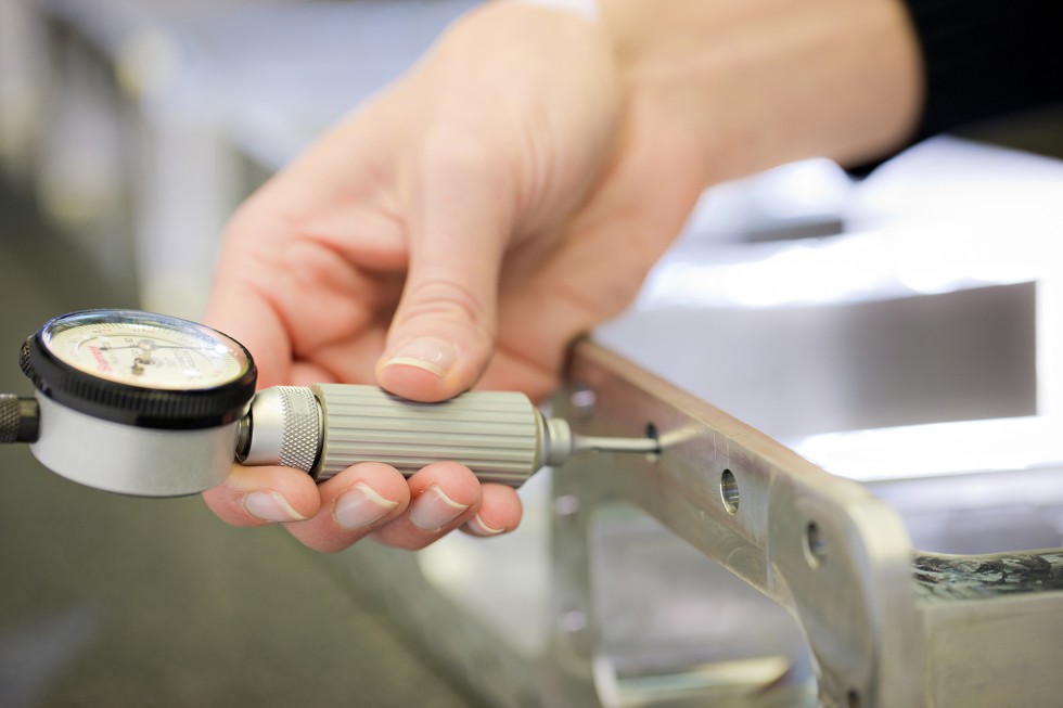 Depicts the usage of an intramike to precisely measure holes in machined parts.