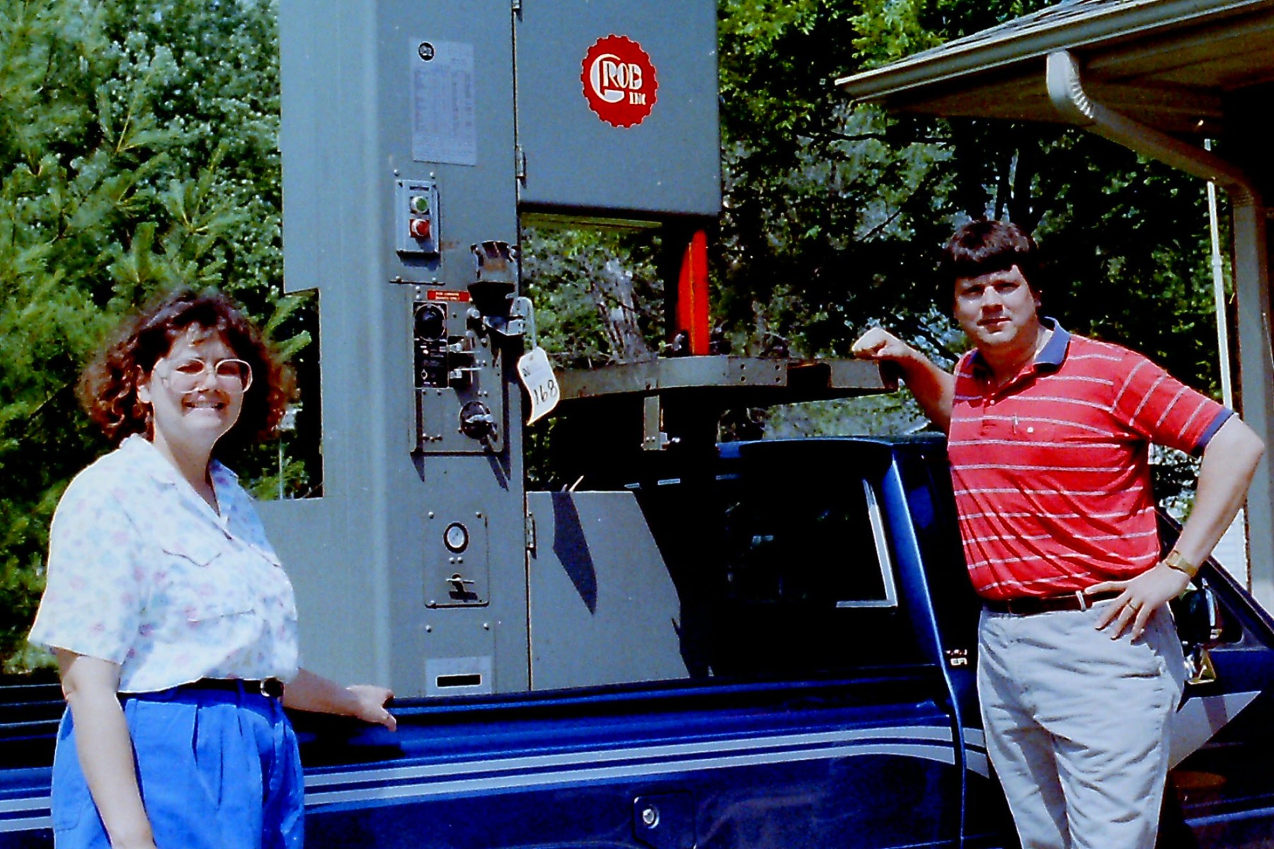 Young Bob and Judy Burns standing in front of a truck, their first machine in the bed.